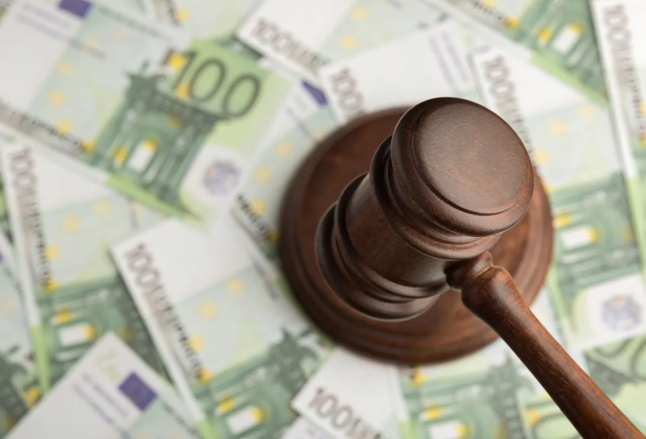 Młotek sędziowski na tle banknot&oacute;w 100 euro. Zastanawiasz się, ile kosztuje upadłość konsumencka?