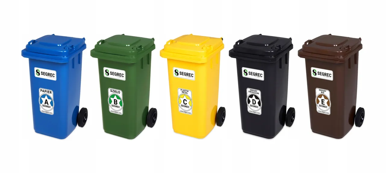 Pięć kolorowych koszy na śmieci: niebieski na papier, zielony na szkło, ż&oacute;łty na plastik i metal, czarny na odpady zmieszane, brązowy na odpady bio.