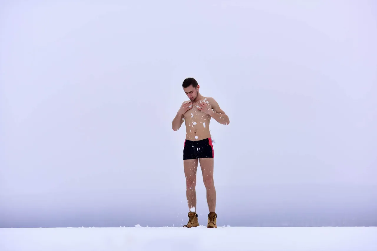 Mężczyzna w kąpiel&oacute;wkach i butach na śniegu, otoczony zimową aurą. Idealny obrazek, by pokazać, jak zacząć morsować.
