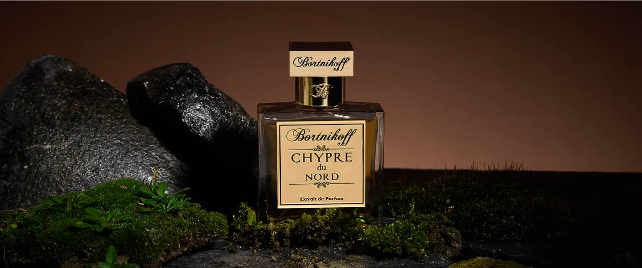 Eleganckie perfumy szyprowe Borinikoff Chypre du Nord w szklanej butelce, otoczone mchem i kamieniami, przywołujące leśną głębię.
