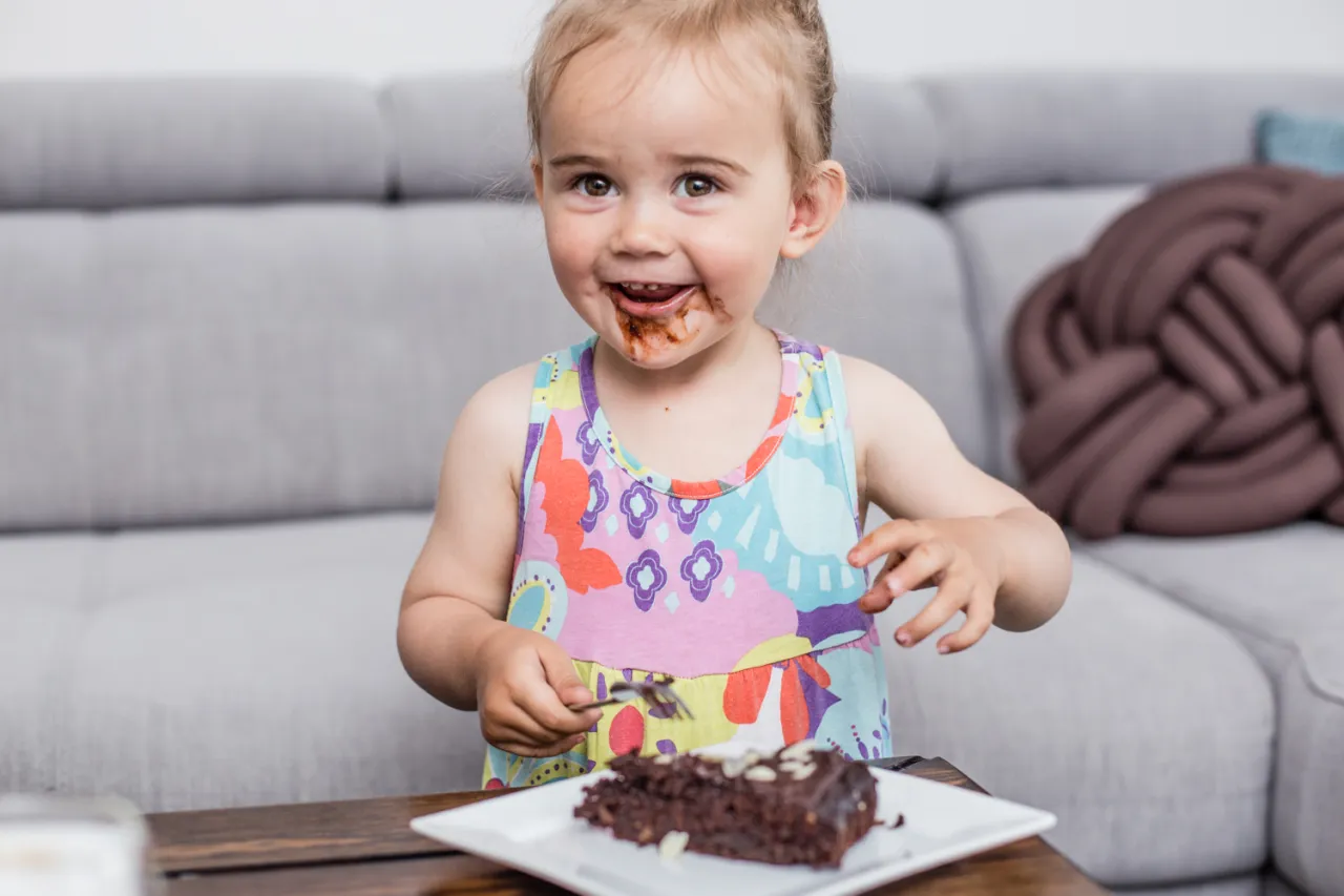 dziecko je czekoladowe ciastko z buraka z uśmiechem