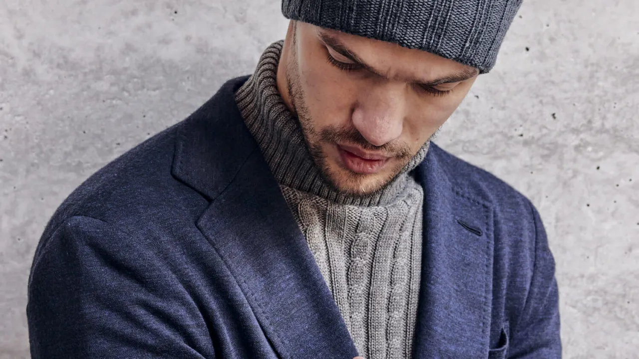 Mężczyzna w garniturze i eleganckiej czapce zimowej