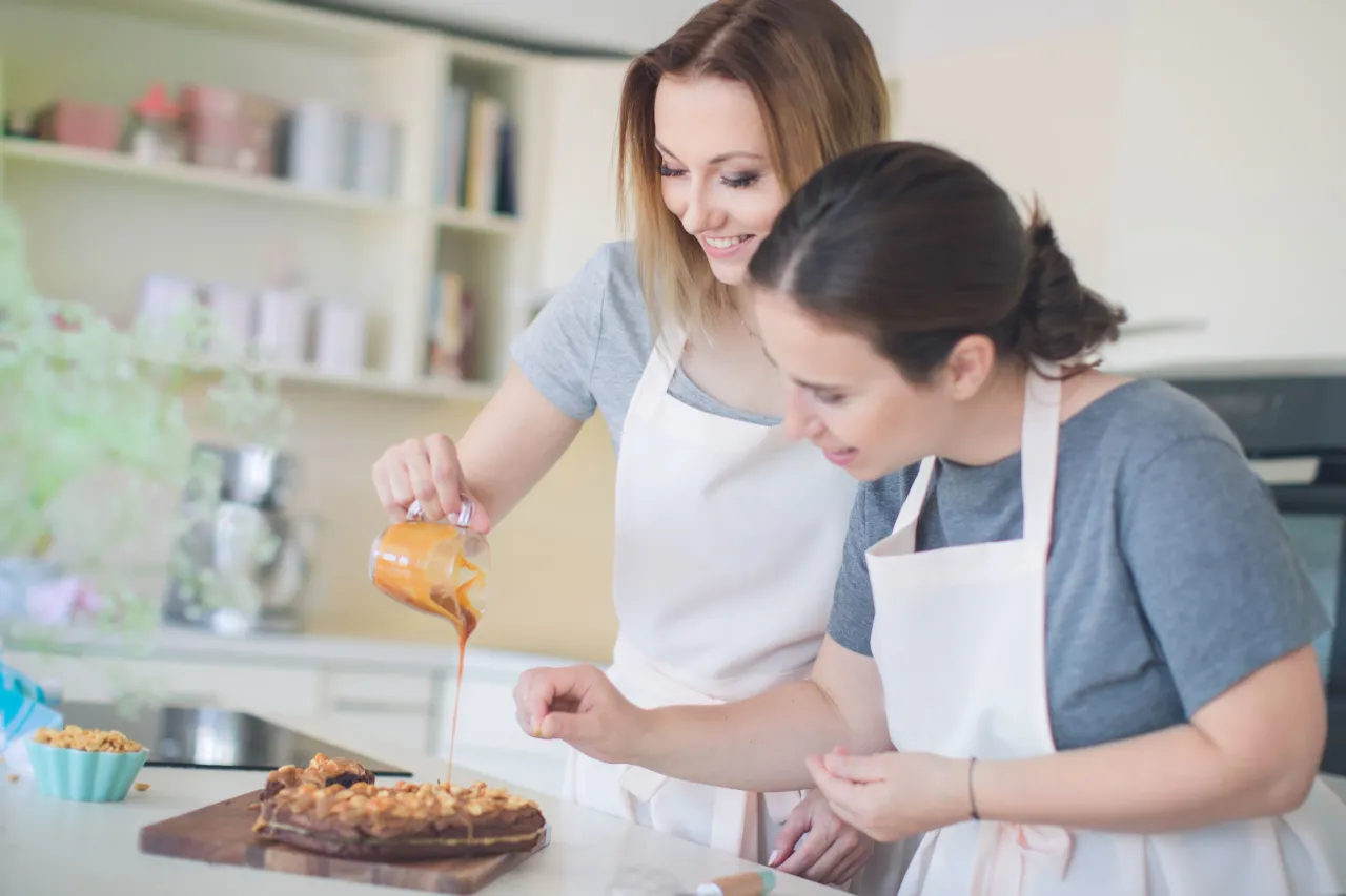 uśmiechnięta kobieta w kuchni piecze szarlotkę