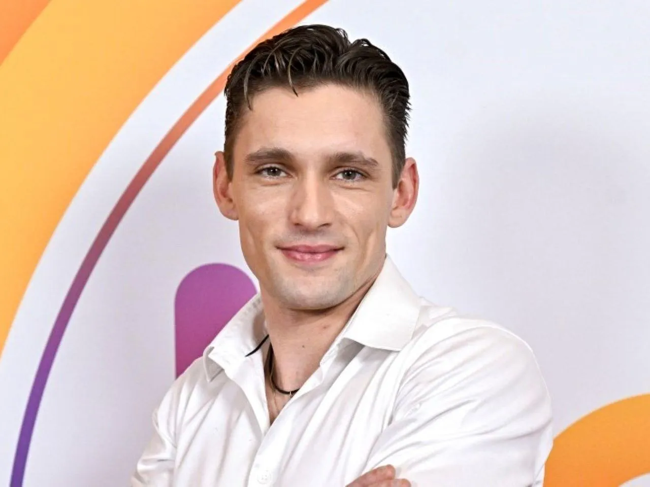 Filip Gurłacz w białej koszuli, uśmiechnięty, z pewnością zgadłby melodię w programie 