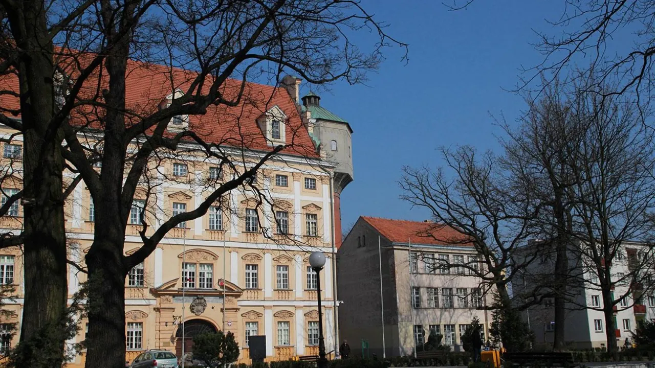 Zamek Piastowski i inne zabytki to miejsca, co zobaczyć w Oławie. Widać tu piękne budynki z czerwonymi dachami i wieżę.