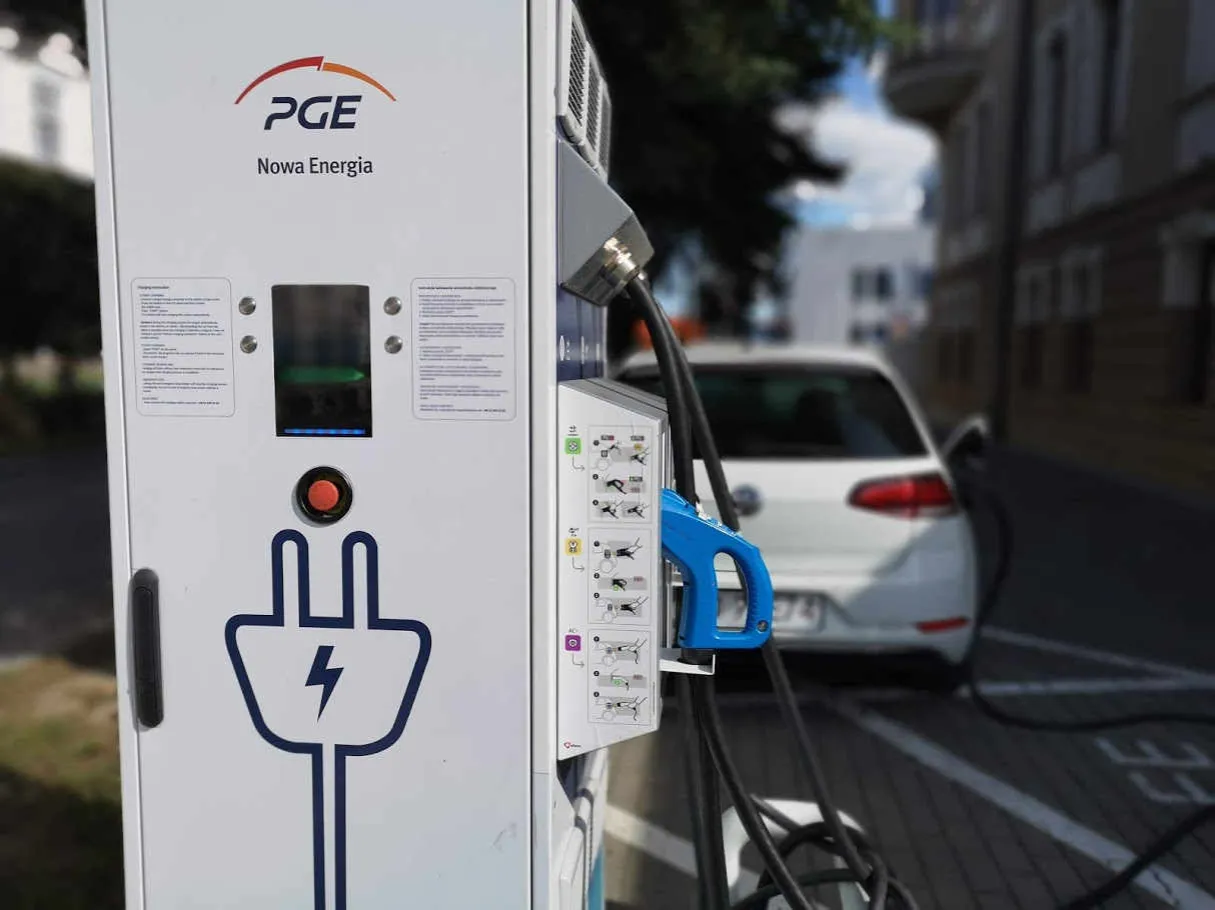 Stacja ładowania PGE z symbolem wtyczki. Dowiedz się, jak otworzyć stację ładowania samochod&oacute;w elektrycznych, by naładować auto.