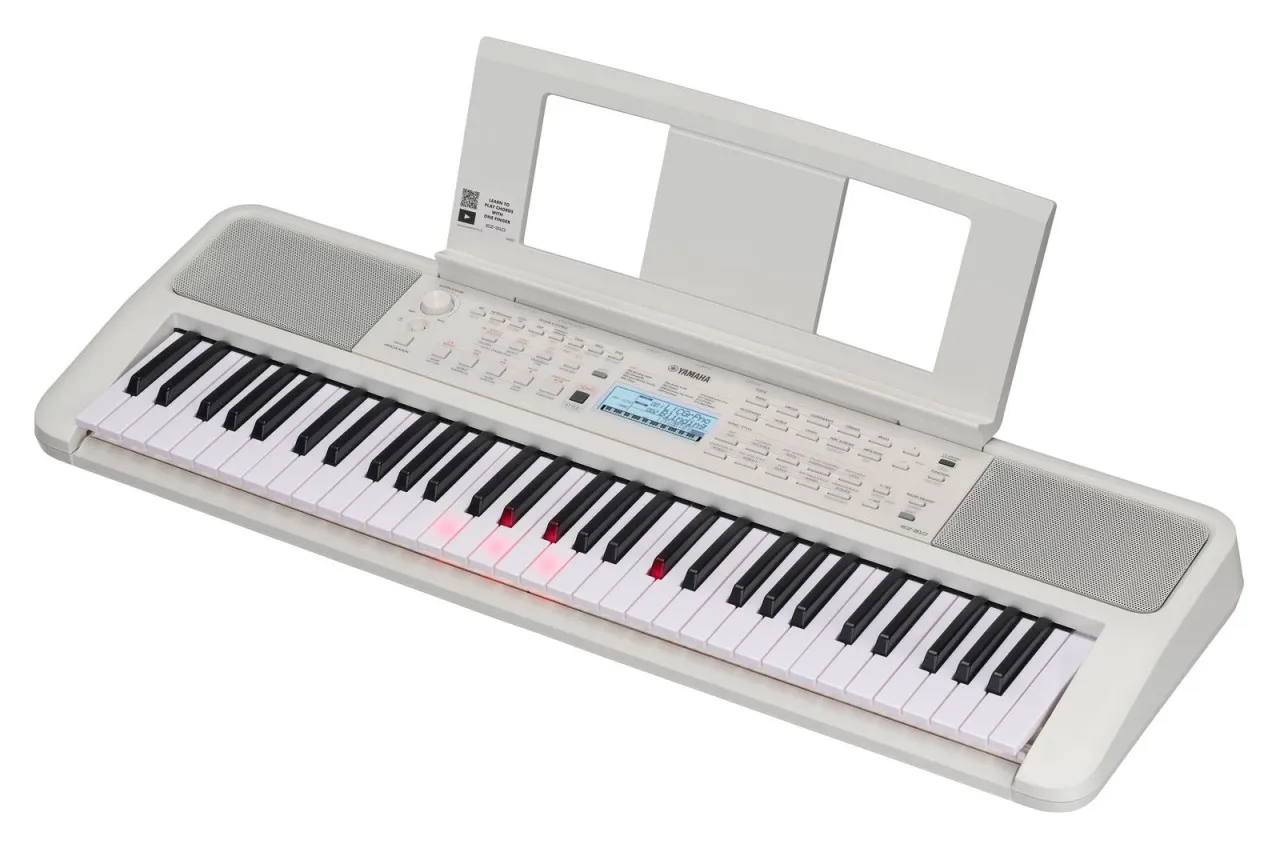 Biały keyboard Yamaha EZ-310, idealny jako keyboard dla dzieci, z podświetlanymi klawiszami i stojakiem na nuty.