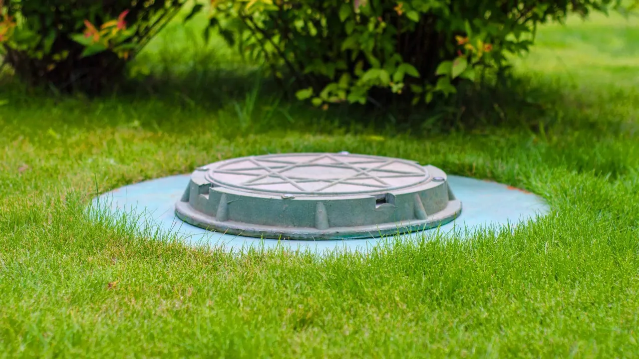 Pokrywa przydomowej oczyszczalni ścieków, dyskretnie ukryta w trawniku. Zastanawiasz się, przydomowa oczyszczalnia ścieków jaką wybrać?