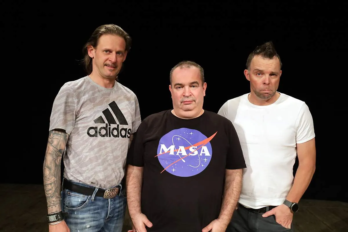 Trzech członk&oacute;w Kabaretu Ani Mru Mru pozuje do zdjęcia. Jeden w koszulce z logo NASA, drugi w szarej z Adidasem, trzeci w białej.
