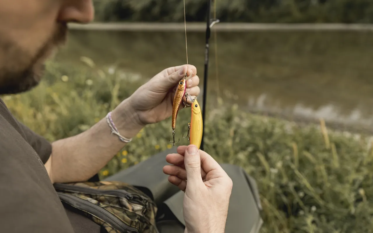 Wędkarz przygotowuje przynęty, by dowiedzieć się, jak złowić sandacza na spinning.