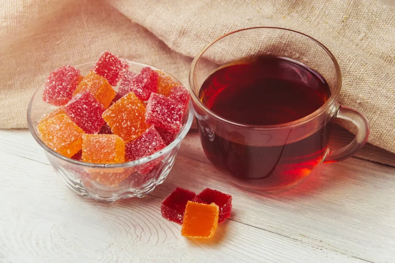 Cukierki galaretki w misce i obok kubek herbaty. Czy w galaretce jest kolagen?