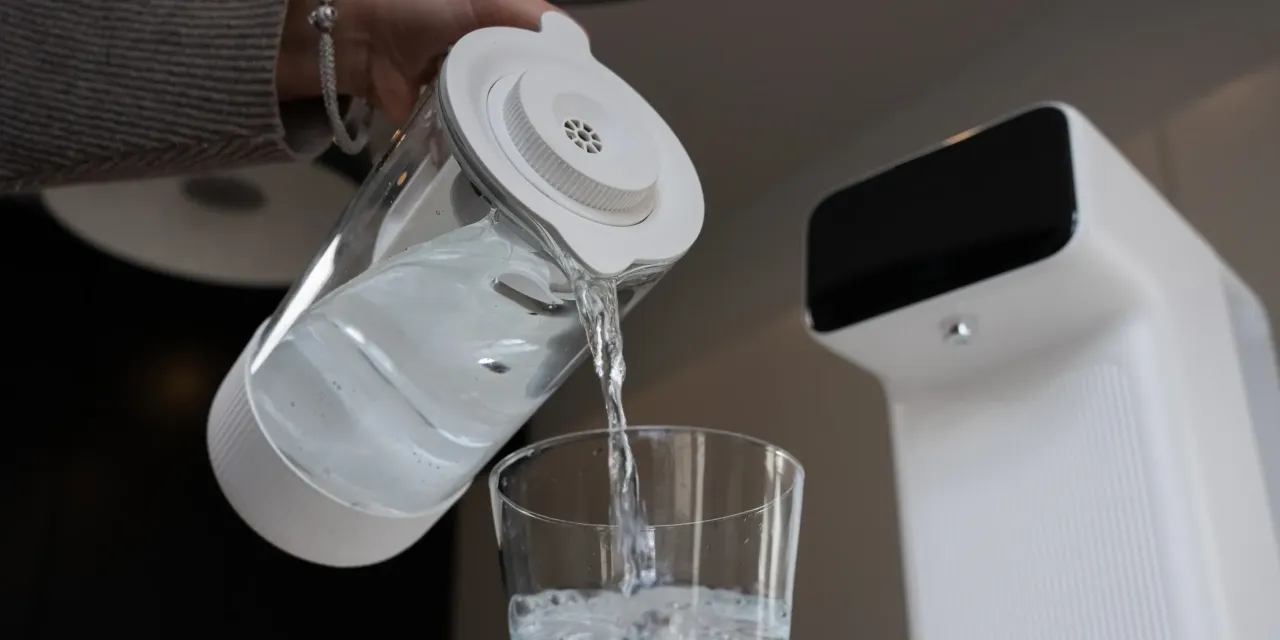 Przelewam wodę z dzbanka z filtrem do kranu do szklanki. To świetny sposób na uzyskanie czystej wody.