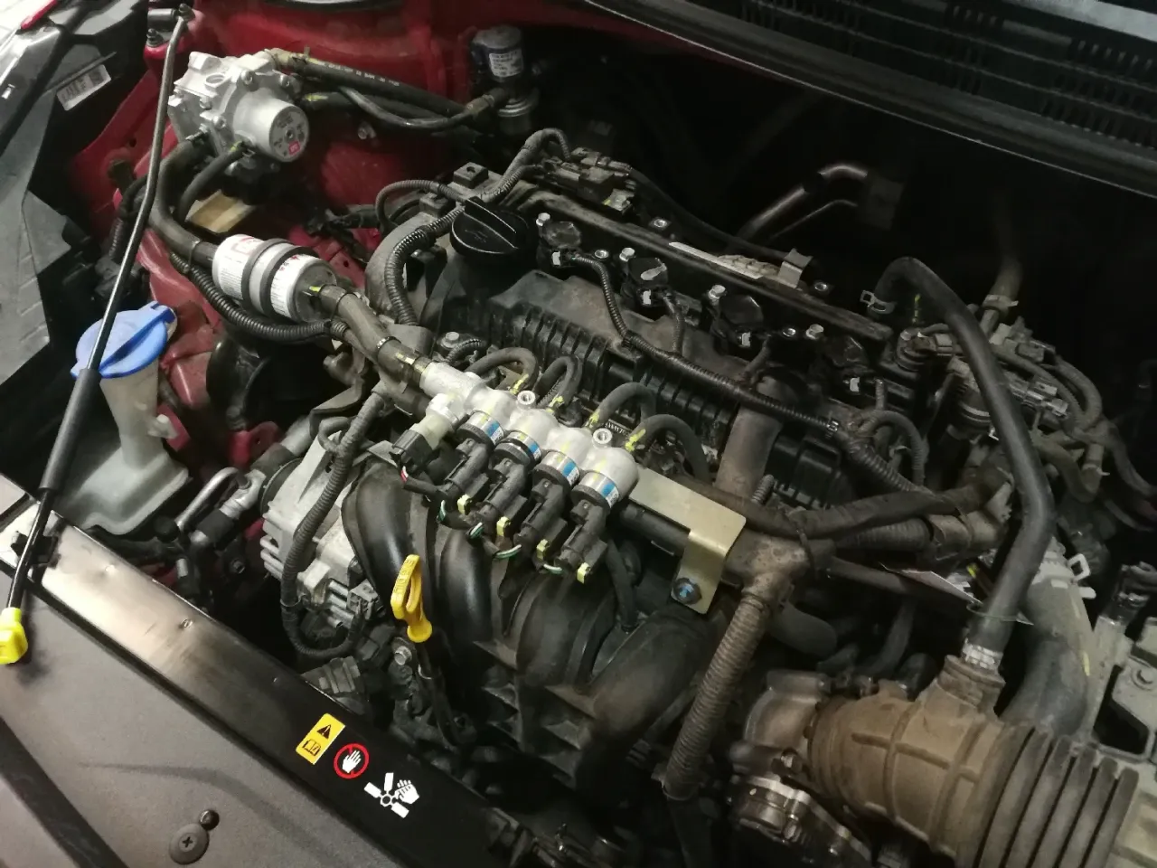 Silnik samochodu z instalacją LPG. Widać wtryskiwacze gazowe i reduktor.