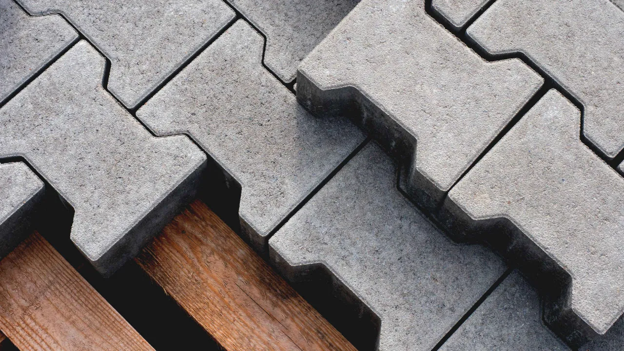 Szare kostki brukowe na drewnianej palecie. Zastanawiasz się, ile kosztuje wybrukowanie podjazdu?