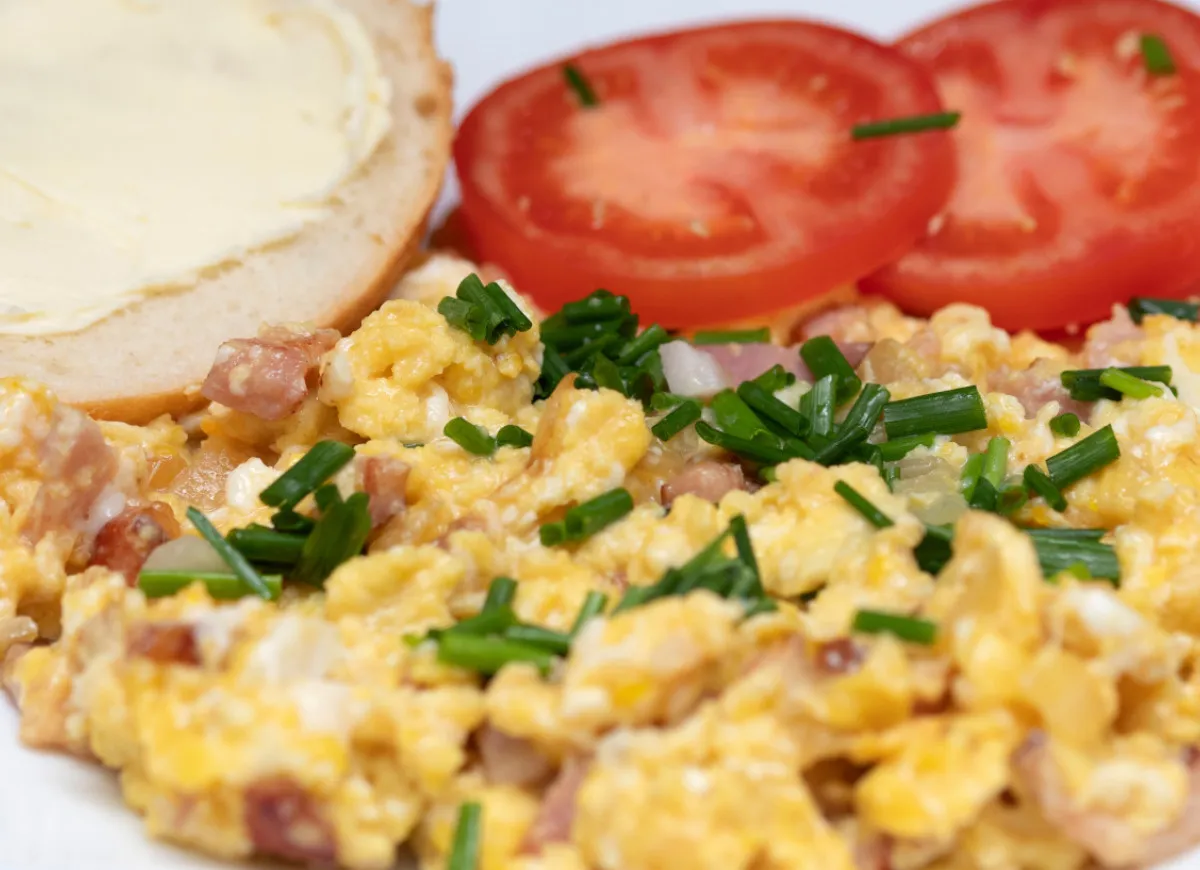Jajecznica z boczkiem i szczypiorkiem, kromka chleba z masłem i pomidory. Czy jajecznica jest dietetyczna? Zależy od dodatków!