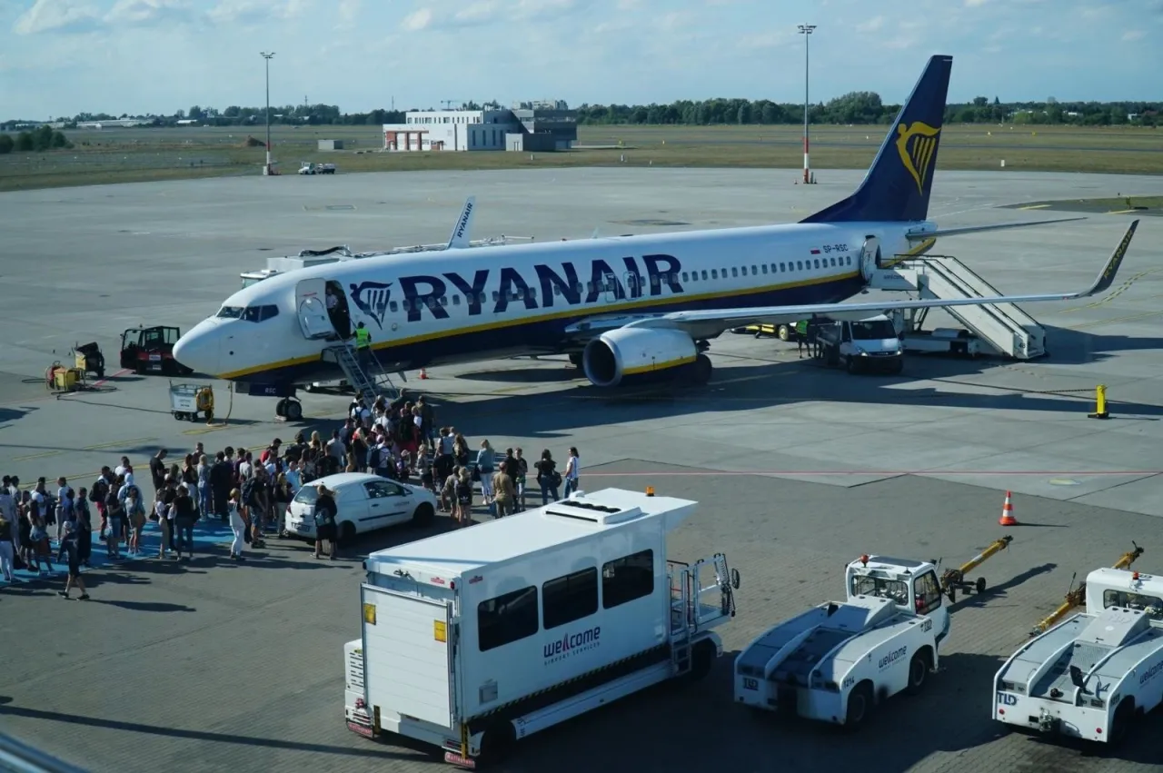 Samolot Ryanair na płycie lotniska, pasażerowie wsiadają. Chcesz wiedzieć, jak przylecieć na Cypr? To może być Twój lot!