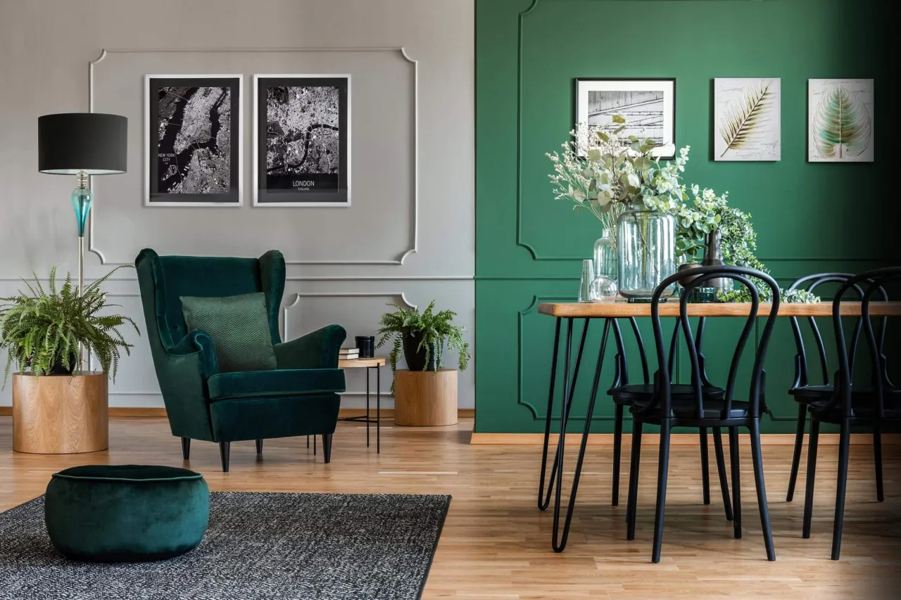 Elegancki salon z butelkową zielenią. Z czym łączyć ten kolor? Z szarością, czernią i naturalnym drewnem.