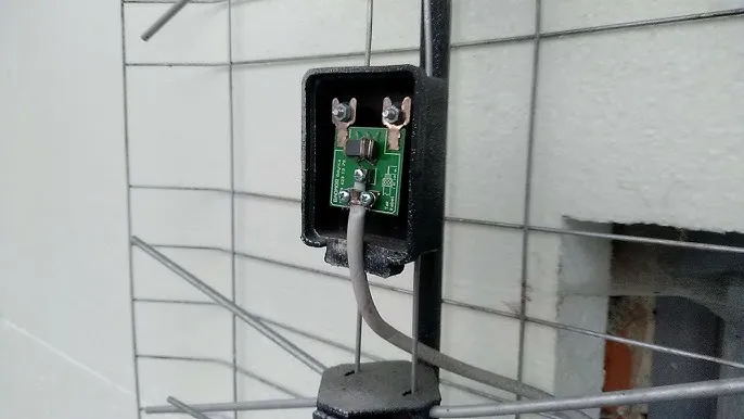 Wnętrze puszki anteny siatkowej, podłączenie kabla do symetryzatora, płytka wzmacniacza antenowego