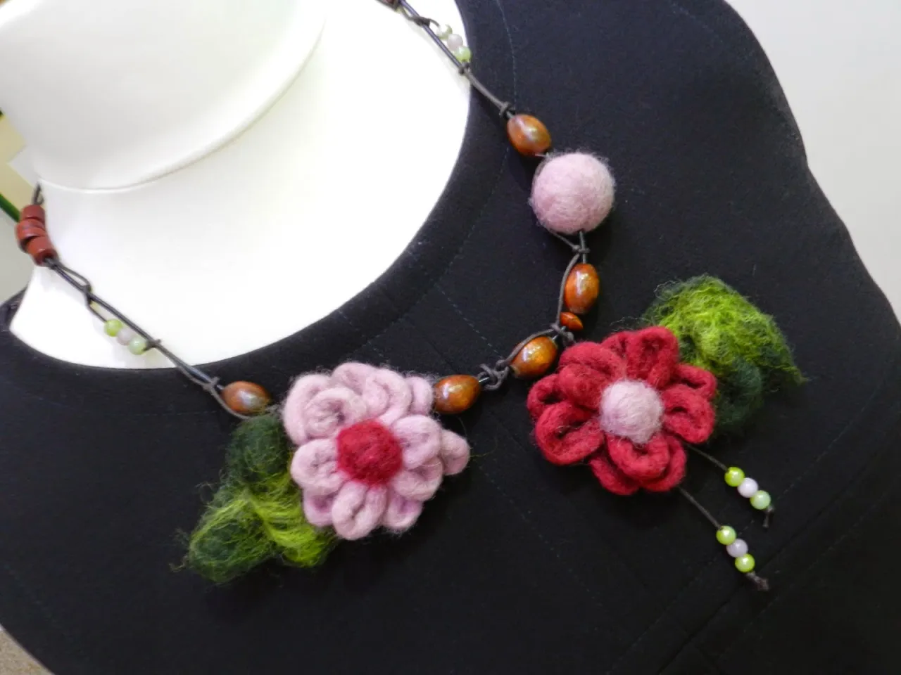 Urocza biżuteria z filcu: naszyjnik z r&oacute;żowymi i czerwonymi kwiatami, zielonymi listkami i drewnianymi koralikami.