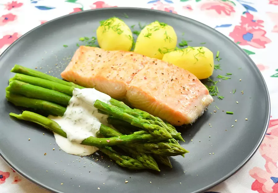 pieczony łosoś z ziemniakami i szparagami na talerzu