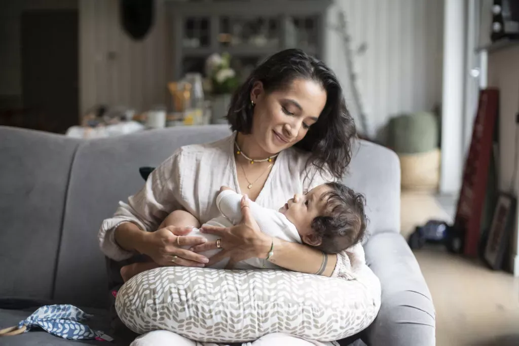 kobieta karmiąca piersią uśmiechnięta z dzieckiem