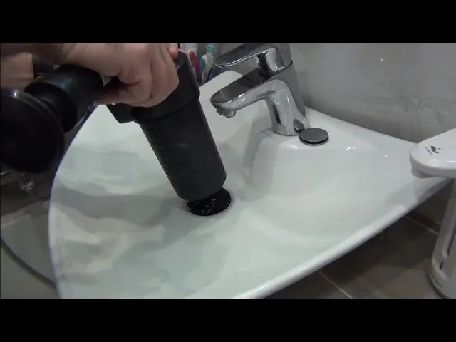 wlewanie środka do udrażniania rur przez plastikowy lejek do zlewu