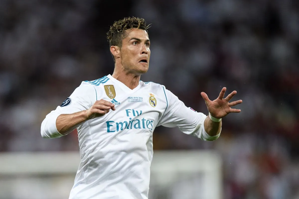 Cristiano Ronaldo w białej koszulce Realu Madryt, świętujący kolejne zwycięstwo. Ile Real Madryt ma puchar&oacute;w Ligi Mistrz&oacute;w? Tyle, ile on ma palc&oacute;w na tej dłoni, plus jeszcze kilka!