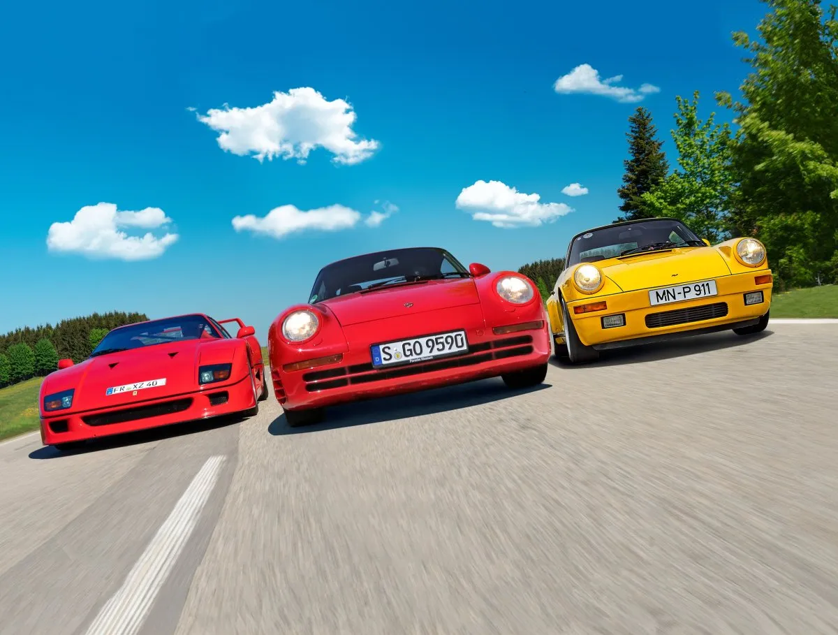 Trzy kultowe samochody: czerwone Ferrari F40, czerwone Porsche 959 i żółte Porsche 911. Które wybrać?