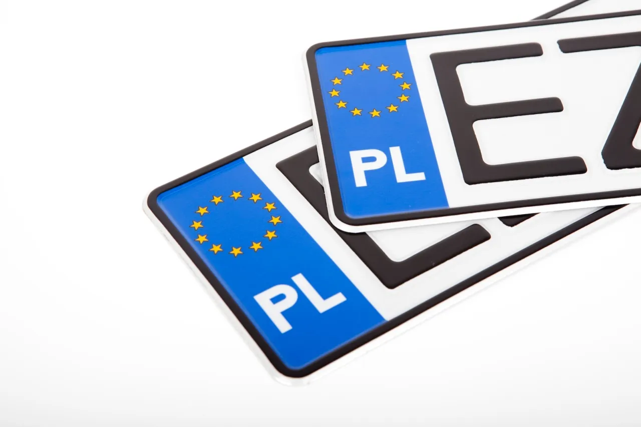 Dwa polskie tablice rejestracyjne z symbolem UE. Zmiana numeru rejestracyjnego a OC to ważna kwestia przy przerejestrowaniu pojazdu.