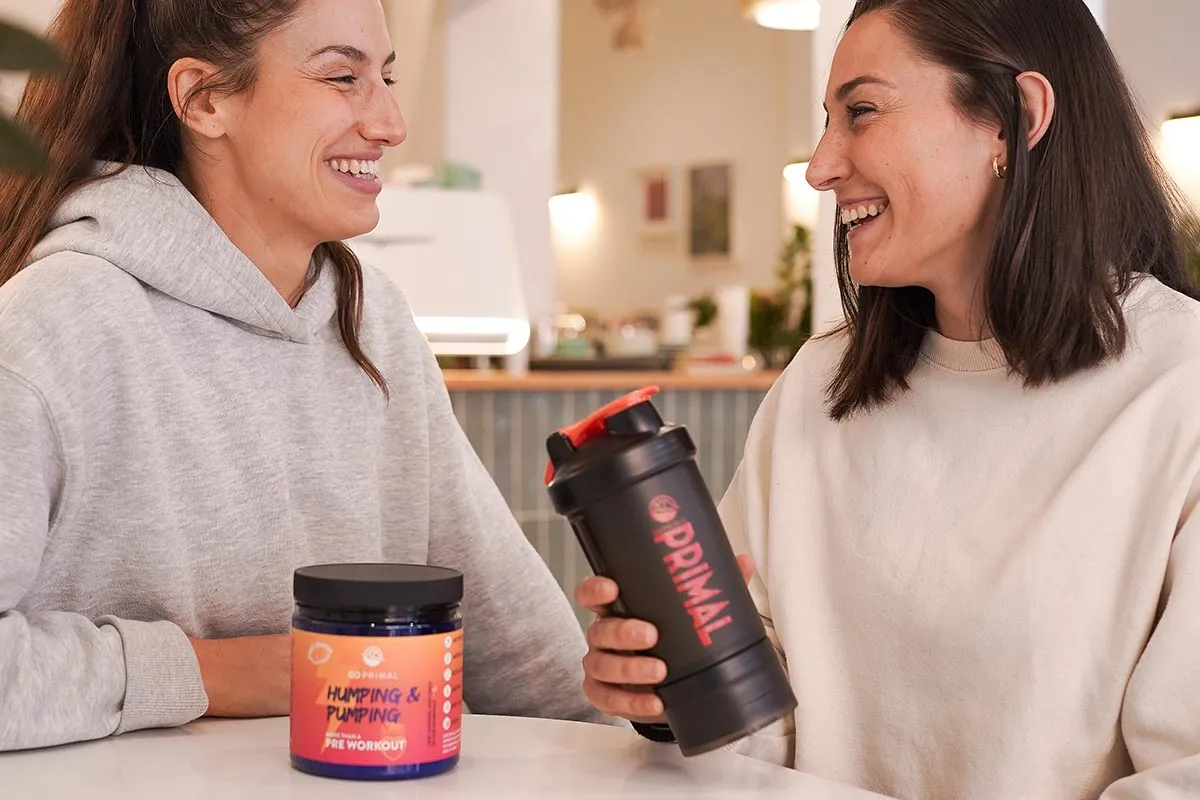 Dwie kobiety rozmawiają o suplementach. Na stole słoik z odżywką 