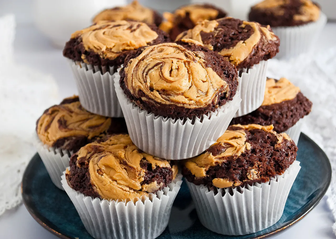 Pyszne muffinki na maślance z czekoladowym ciastem i kremowym masłem orzechowym, ułożone na talerzu.