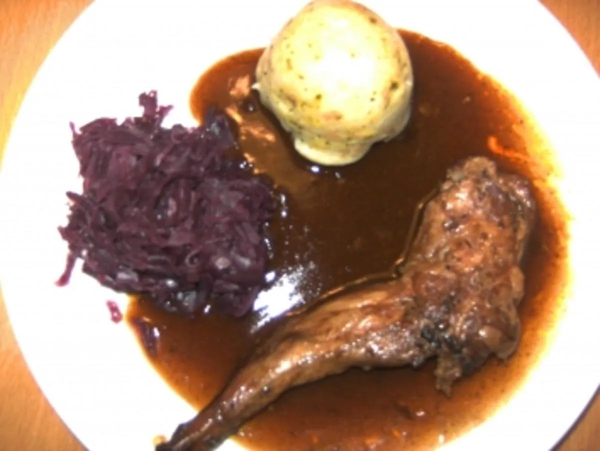Kaninchenbraten mit So&szlig;e und Kr&auml;utern auf Teller