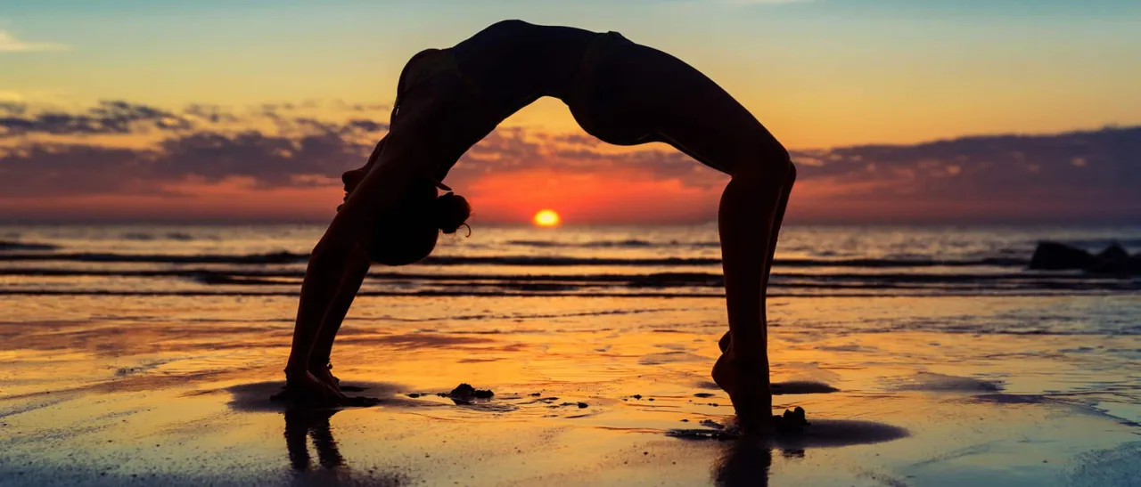 Osoba rozciągająca się rano, wschodzące słońce