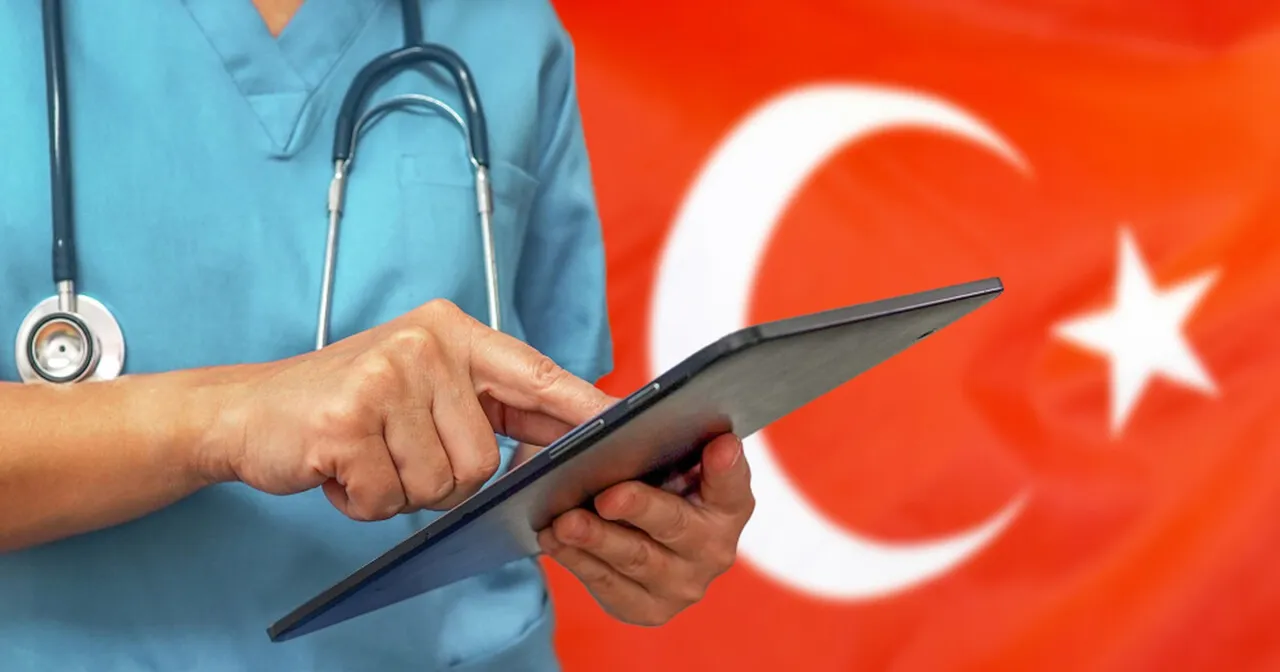 Lekarz w turkusowym uniformie ze stetoskopem analizuje dane na tablecie. Tło stanowi flaga Turcji, sugerując analizę koszt&oacute;w leczenia w Turcji.