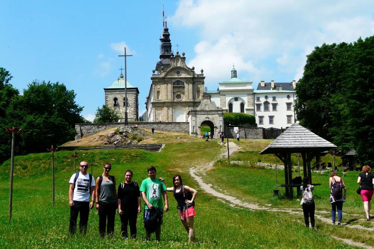 Grupa turyst&oacute;w na tle klasztoru na Świętym Krzyżu, gdzie według legendy znajduje się gr&oacute;b legendarnego kr&oacute;la Bolesława Śmiałego.