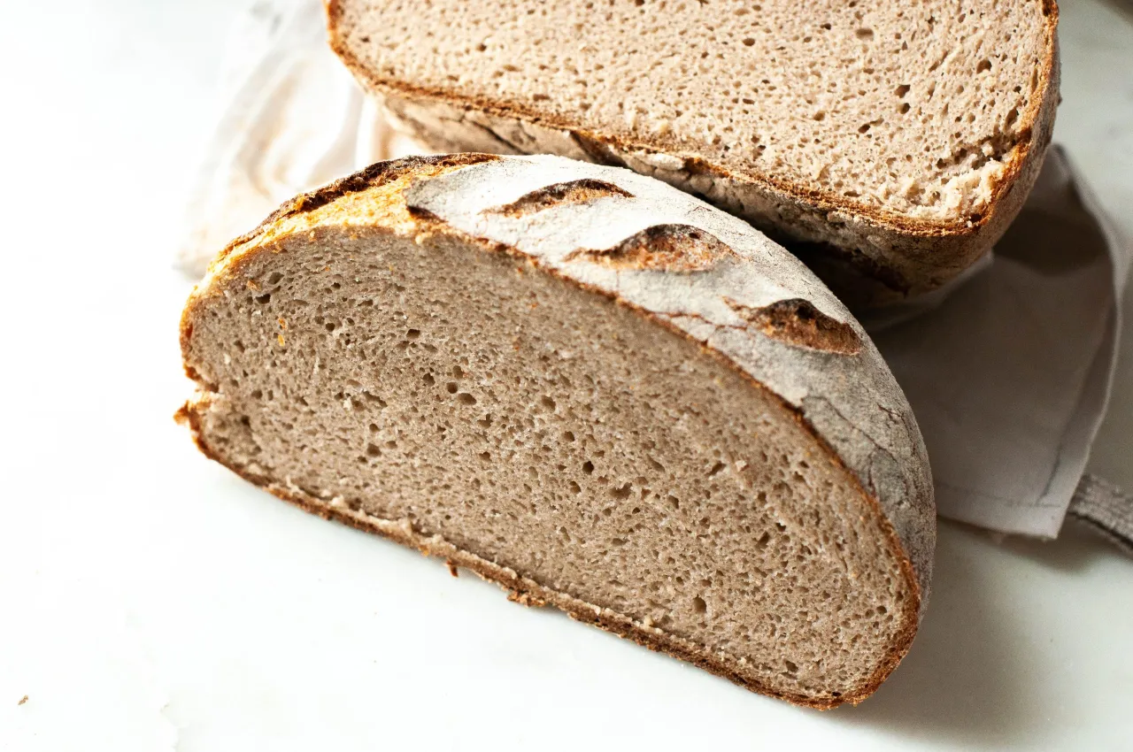 Dwa kawałki chleba na białym tle. Jeden kawałek jest większy i leży z przodu, drugi mniejszy z tyłu. Czy mokry chleb w środku można jeść?