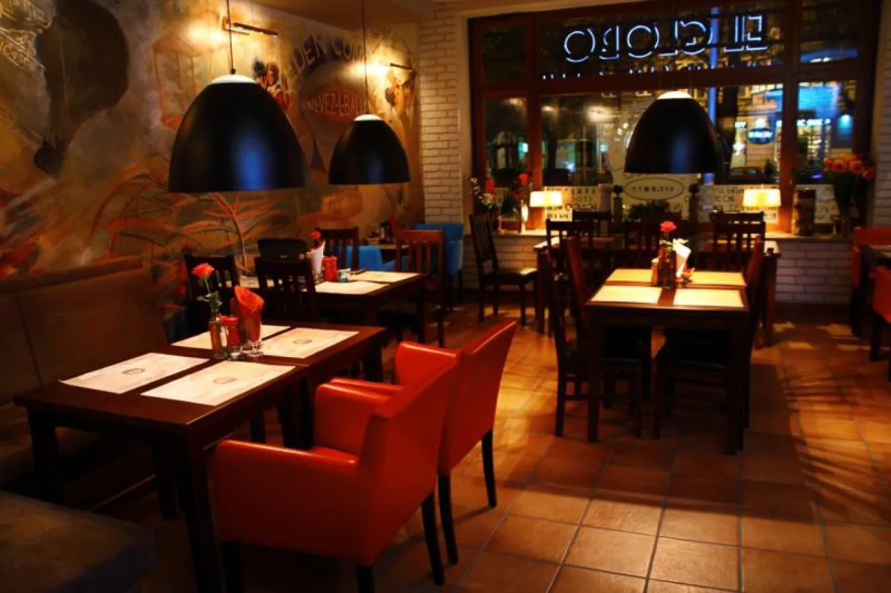 Przytulne wnętrze restauracji w Szczecinie, idealne miejsce, gdzie zjeść w Szczecinie. Czerwone fotele i ciepłe oświetlenie tworzą miłą atmosferę.