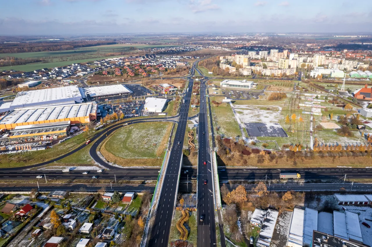 Widok z lotu ptaka na drogę krajową 88 z samochodami i ciężar&oacute;wkami. W tle zabudowania miejskie i pola.