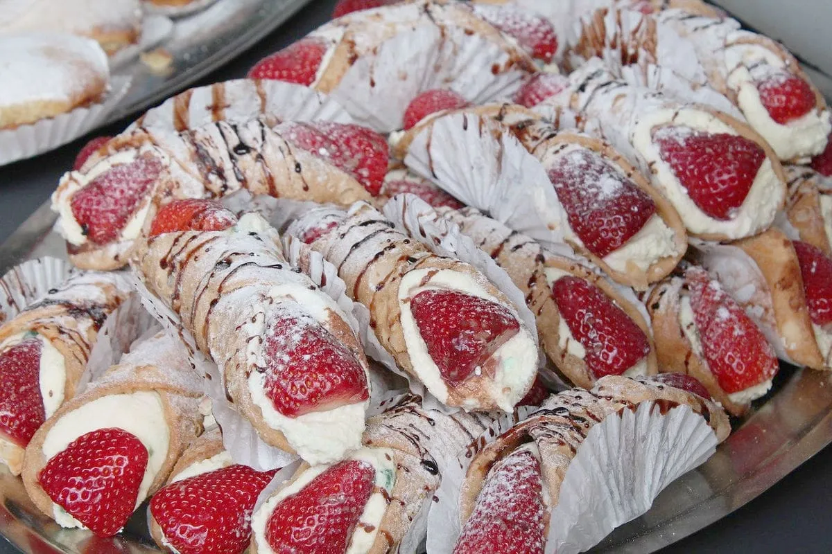 Pyszne cannoli z kremem i truskawkami, posypane cukrem pudrem i polane czekoladą. Idealny przepis na cannoli!