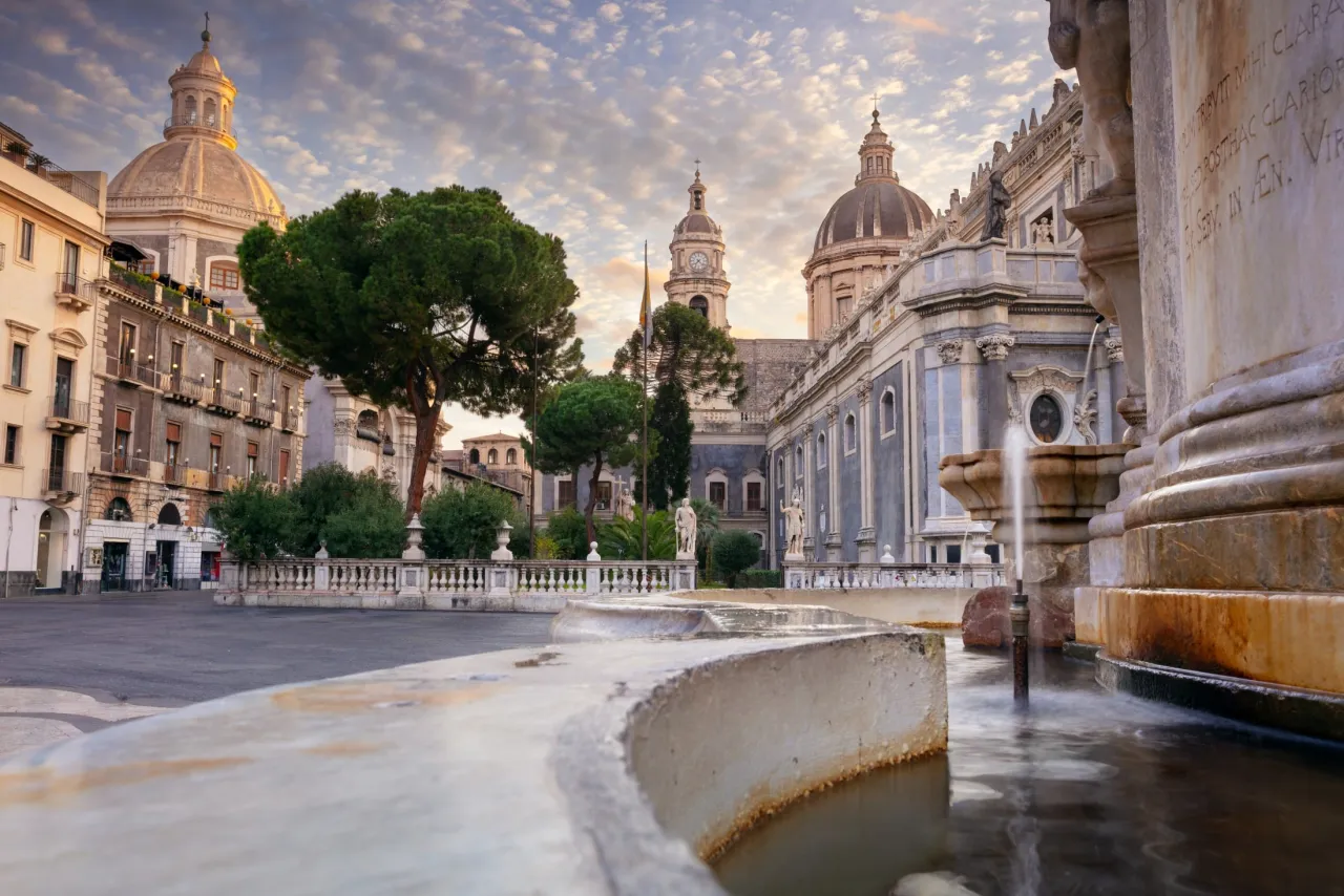 Fontanna w Katanii, z kopułami katedry w tle. Spokojna atmosfera, więc czy w Katanii jest bezpiecznie? Tak, to piękne miasto.