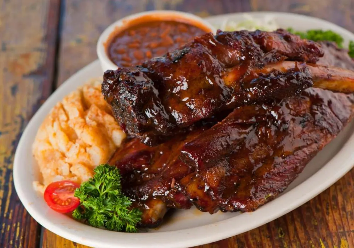 Soczyste żeberka w sosie BBQ, podane z puree ziemniaczanym i fasolką. Idealne pytanie: co ugotować na żeberkach?