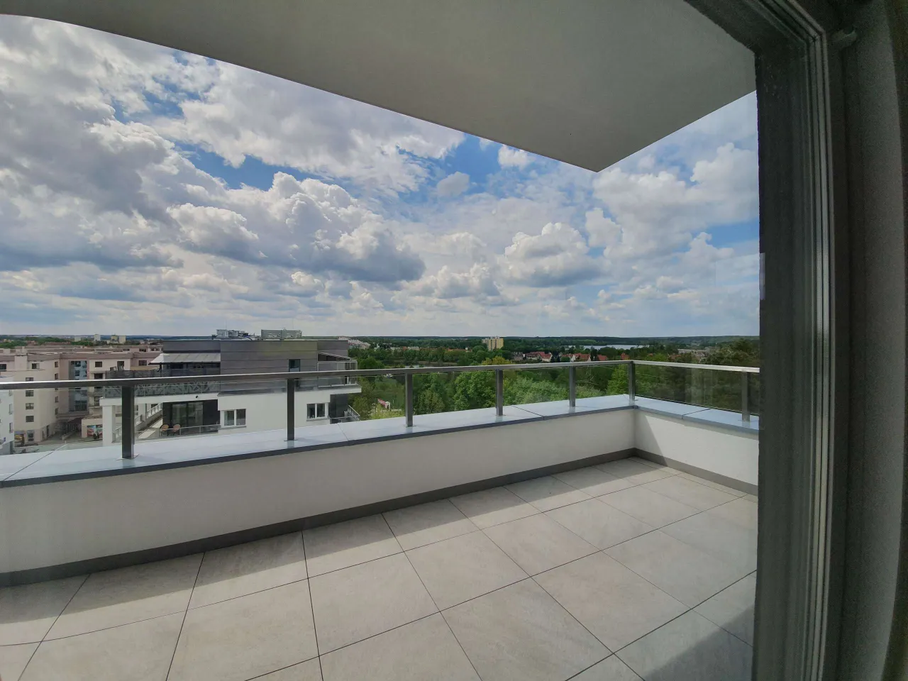 Nowy, przestronny taras z widokiem na miasto i zieleń. Idealne miejsce na poranną kawę.