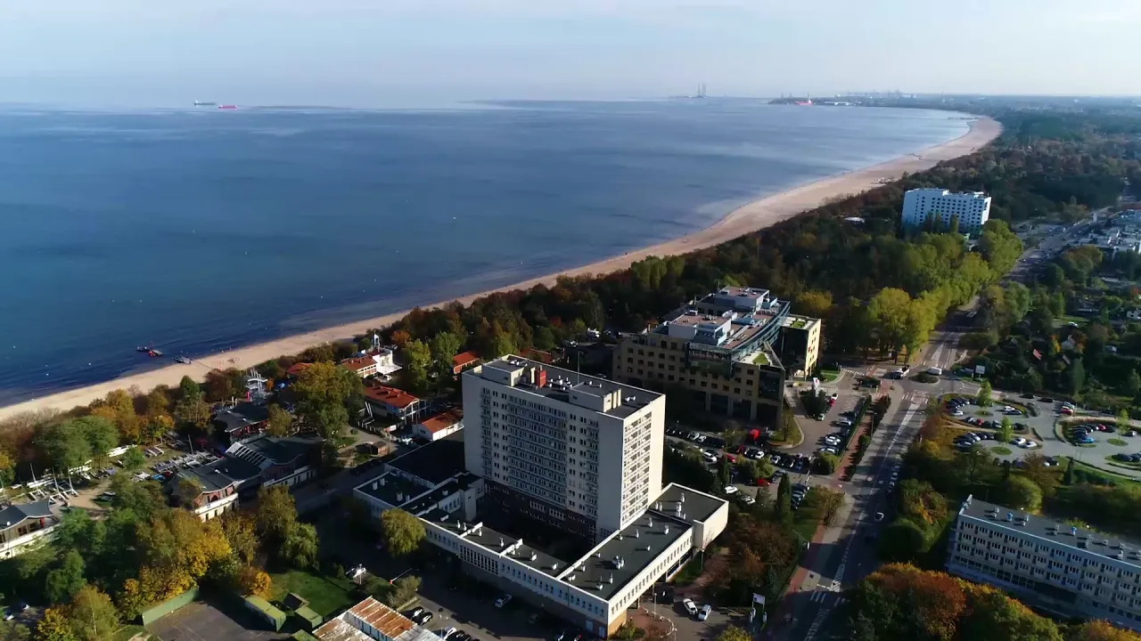 Widok z lotu ptaka na sanatorium MSWiA Sopot, z plażą i morzem w tle.