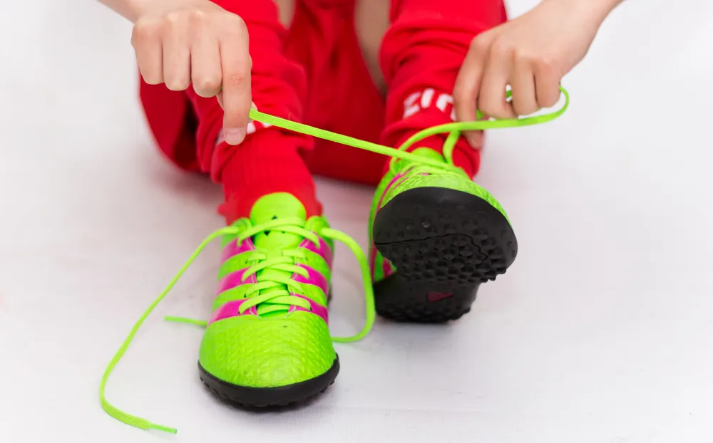 Dziecko mierzące stopę do but&oacute;w piłkarskich