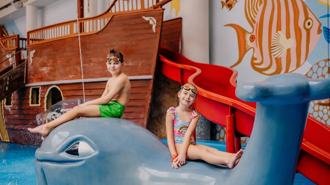 Dzieci bawiące się w aquaparku, basen, zjeżdżalnie