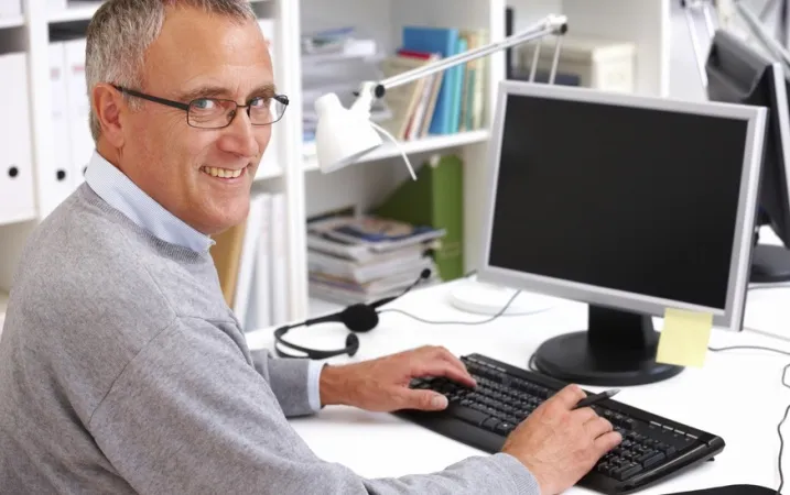 Dyrektor szkoły pracuje przy komputerze SIO