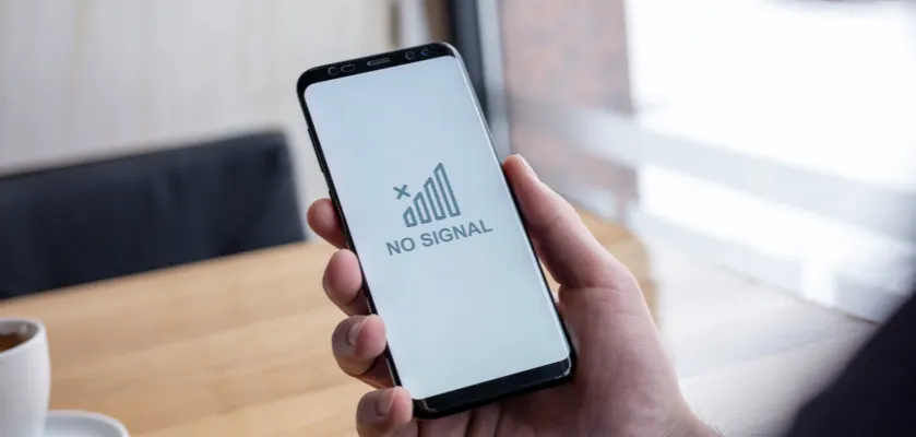 osoba trzyma telefon szukając zasięgu