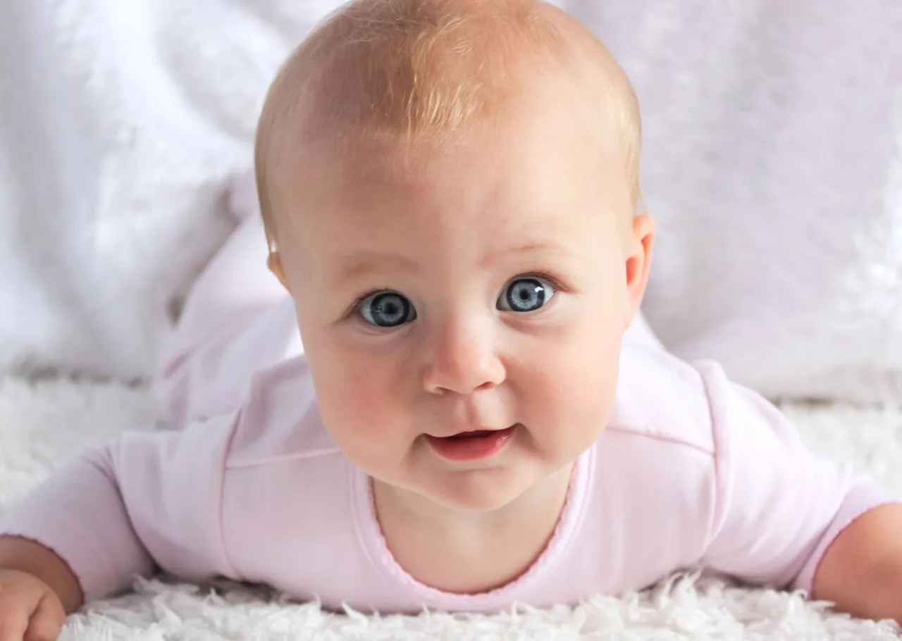 niemowlę z uśmiechem na brzuszku