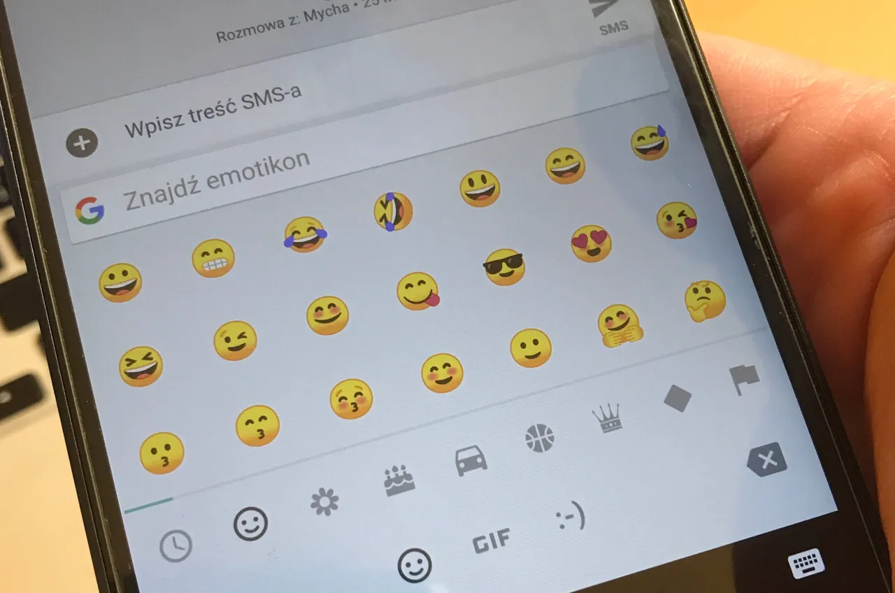 smartfon z otwartą aplikacją Messenger i ikonami emoji