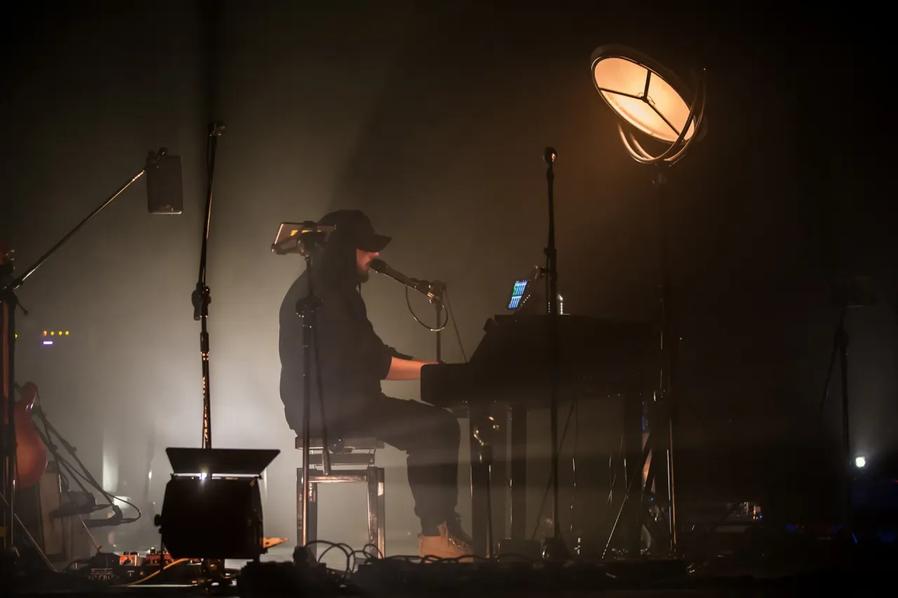 Artysta grający na keyboardzie na scenie. Warto wiedzieć, ile trwa koncert Korteza, by zaplanować wiecz&oacute;r.